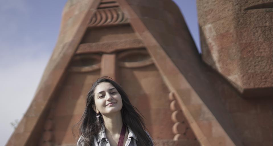 Journalist Lika Zakaryan standing before "We Are Our Mountains" monument north of Stepanakert, the capital city of the Republic of Artsakh